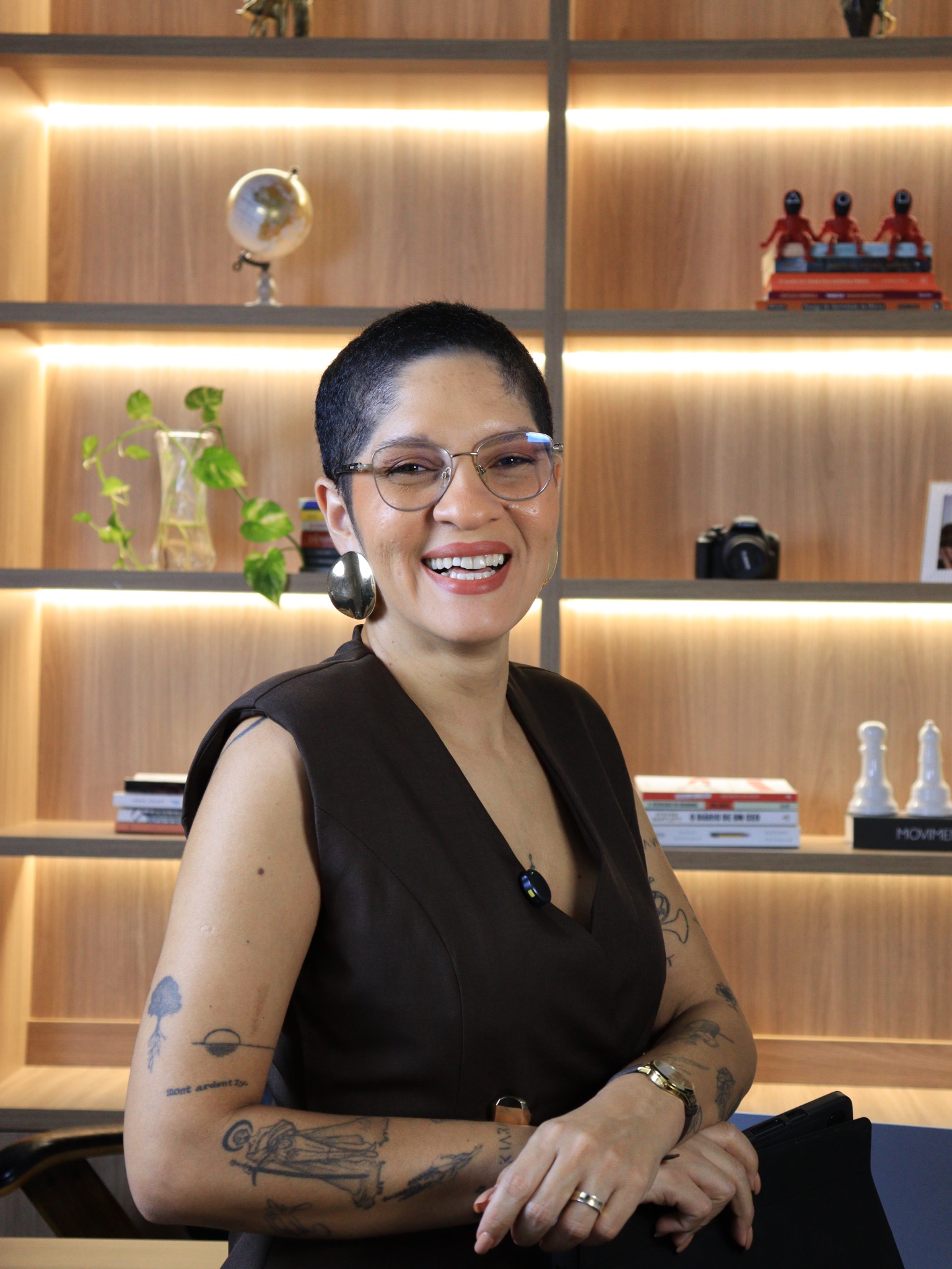 Maiara Gomes sorrindo em seu espaço de trabalho
